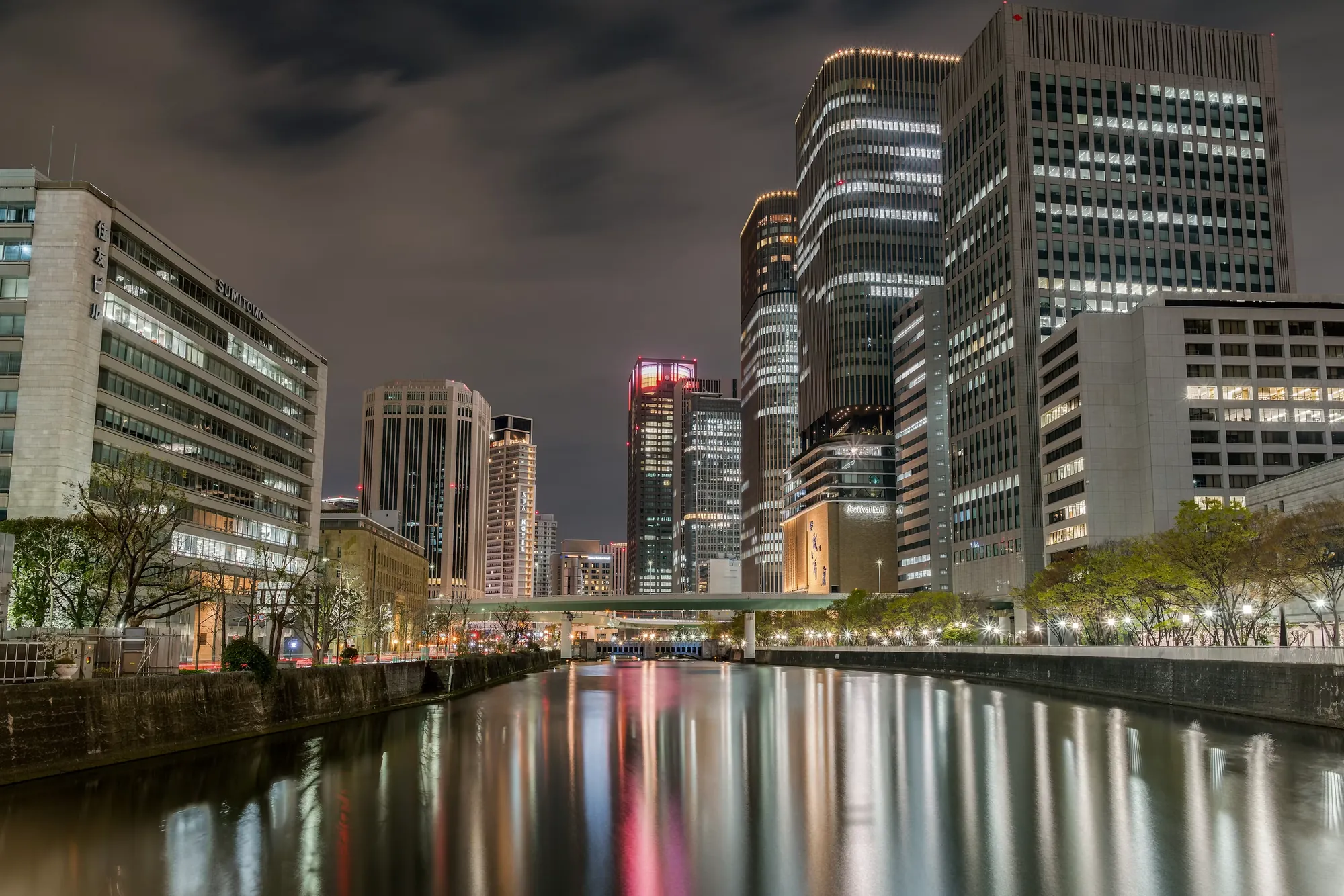 The Nakanoshima riverside in Osaka at night, lights reflected in the river